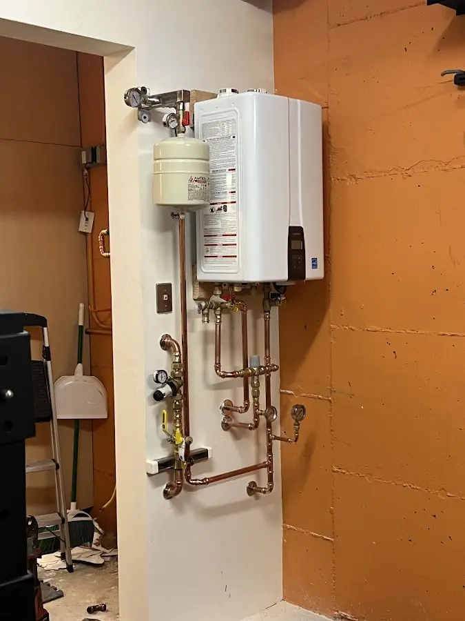 Plumbing technician inspecting water heater connections in Broadview